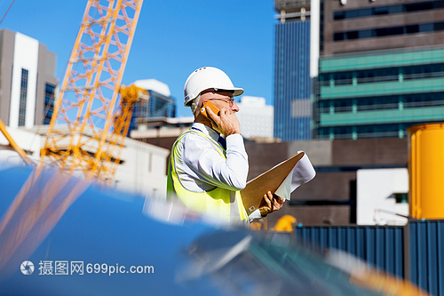 建筑工地的工程师建设者工程师建筑工人施工场景穿着安全背心记事本