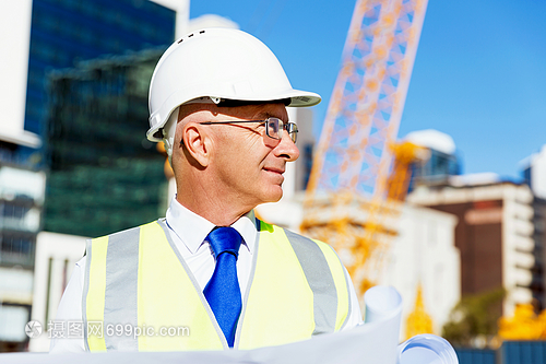 建筑工地的工程师建设者工程师建筑工人施工场景穿着带蓝图的安全背心